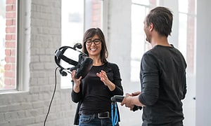 Kvinde der smiler mens hun holder VR briller