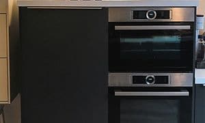 Oven and a fridge with blue glasses and a speaker on top