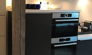 Fridge and oven in black with blue glasses on top