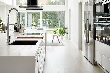 hvidt køkken med køkkenø og amerikanske køleskabe